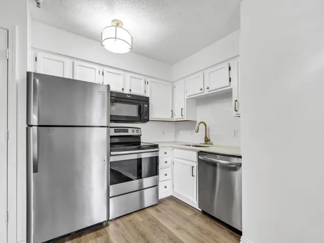a kitchen with stainless steel appliances a refrigerator sink and microwave