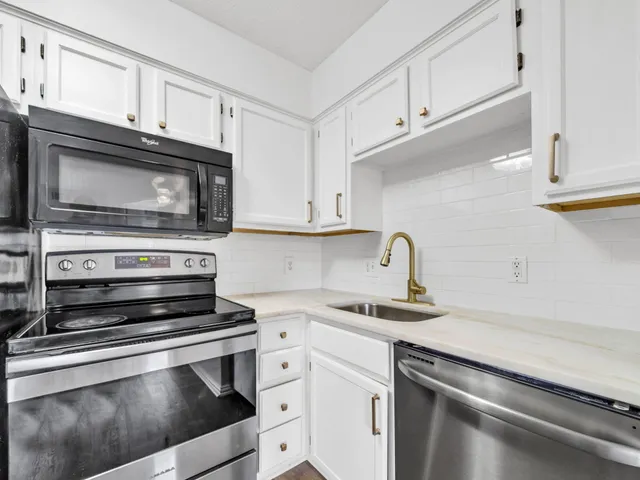 a kitchen with granite countertop a stove microwave and sink