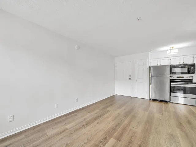 a view of kitchen with wooden floor and electronic appliances