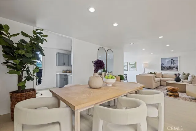 a dining room with furniture a potted plant and wooden floor
