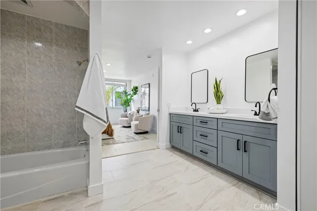 a spacious bathroom with a granite countertop sink mirror and bathtub