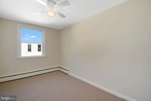 a view of a room with a window and a ceiling fan
