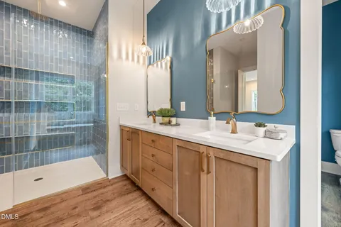 a bathroom with a double vanity sink mirror and shower