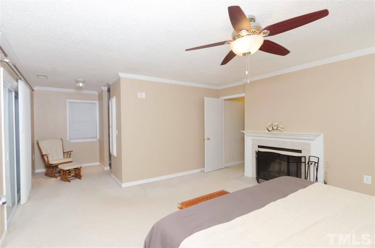 721 Locust Lane Raleigh, NC 27603 - Photo 14 of 22 a bedroom with a bed and a fireplace