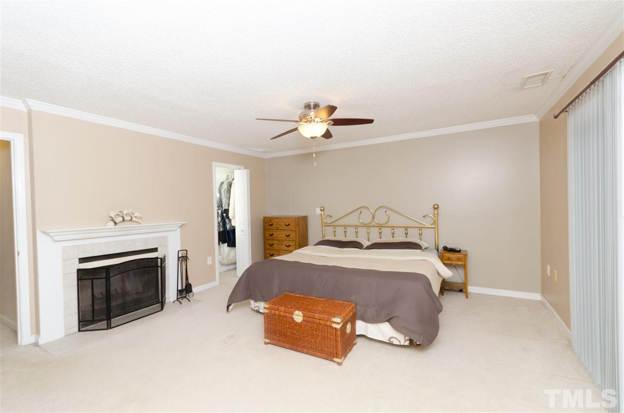 721 Locust Lane Raleigh, NC 27603 - Photo 15 of 22 a bedroom with a bed and a fireplace