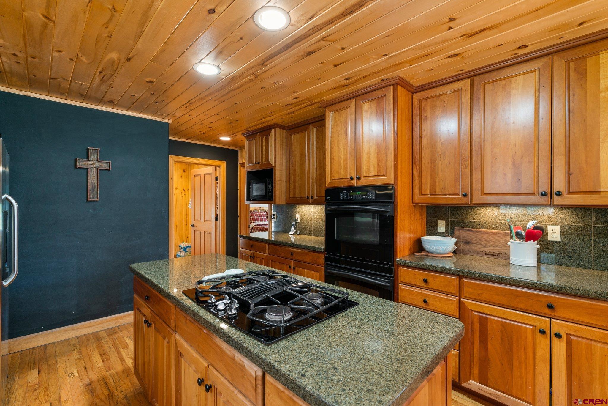 29 Eckart Lane Durango, CO 81301 - Photo 10 of 34 a kitchen with granite countertop stainless steel appliances and wooden cabinets