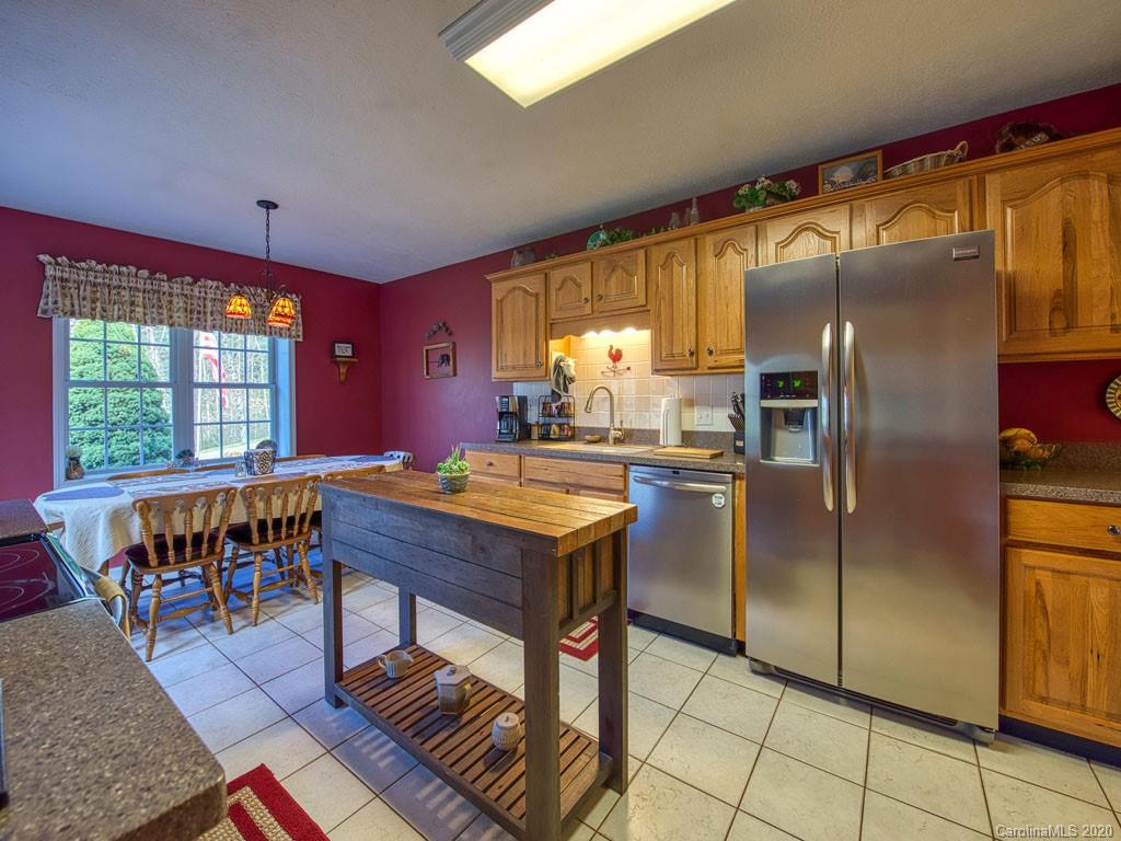 208 Oak Ridge Drive Clyde, NC 28721 - Photo 14 of 36 a kitchen with a table chairs and refrigerator