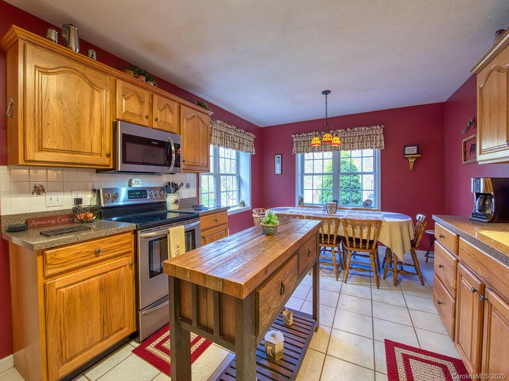 208 Oak Ridge Drive Clyde, NC 28721 - Photo 15 of 36 a kitchen with stainless steel appliances granite countertop a stove top oven a sink dishwasher and cabinets with wooden floor