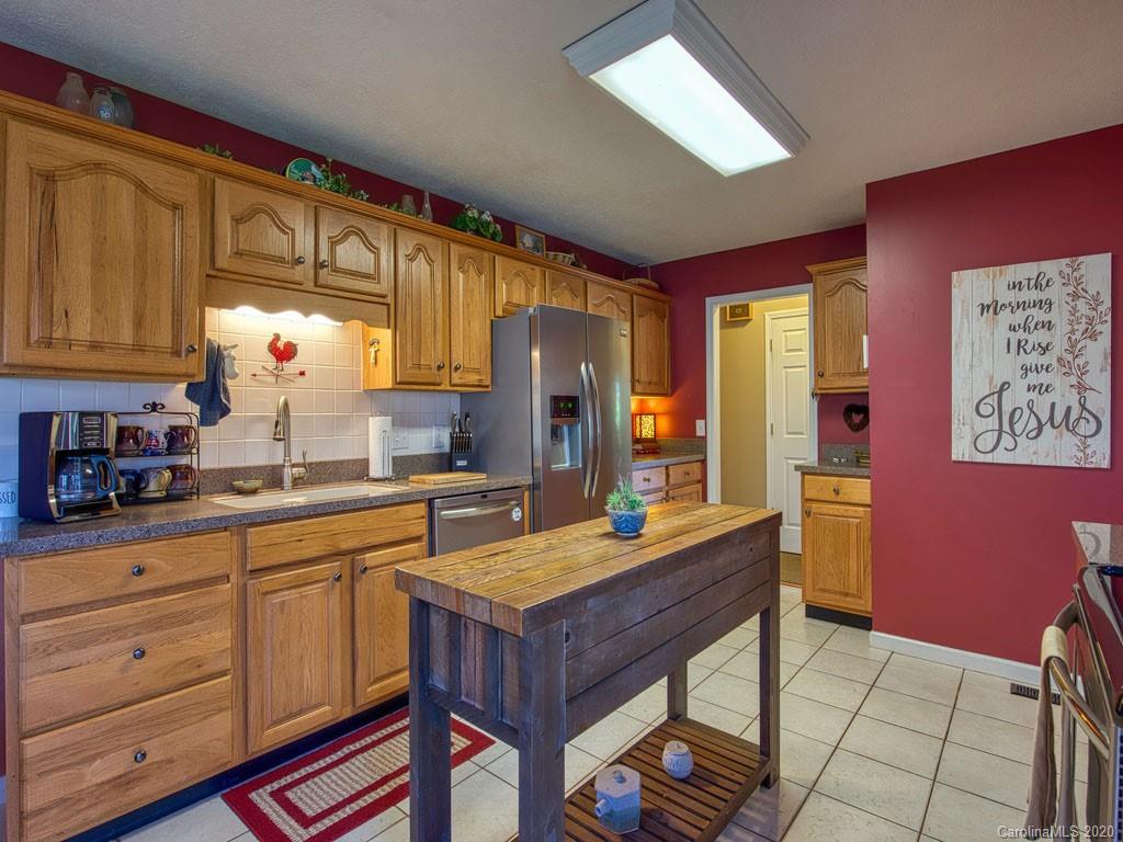 208 Oak Ridge Drive Clyde, NC 28721 - Photo 16 of 36 a kitchen with stainless steel appliances granite countertop a sink dishwasher a microwave oven with granite countertops and cabinets