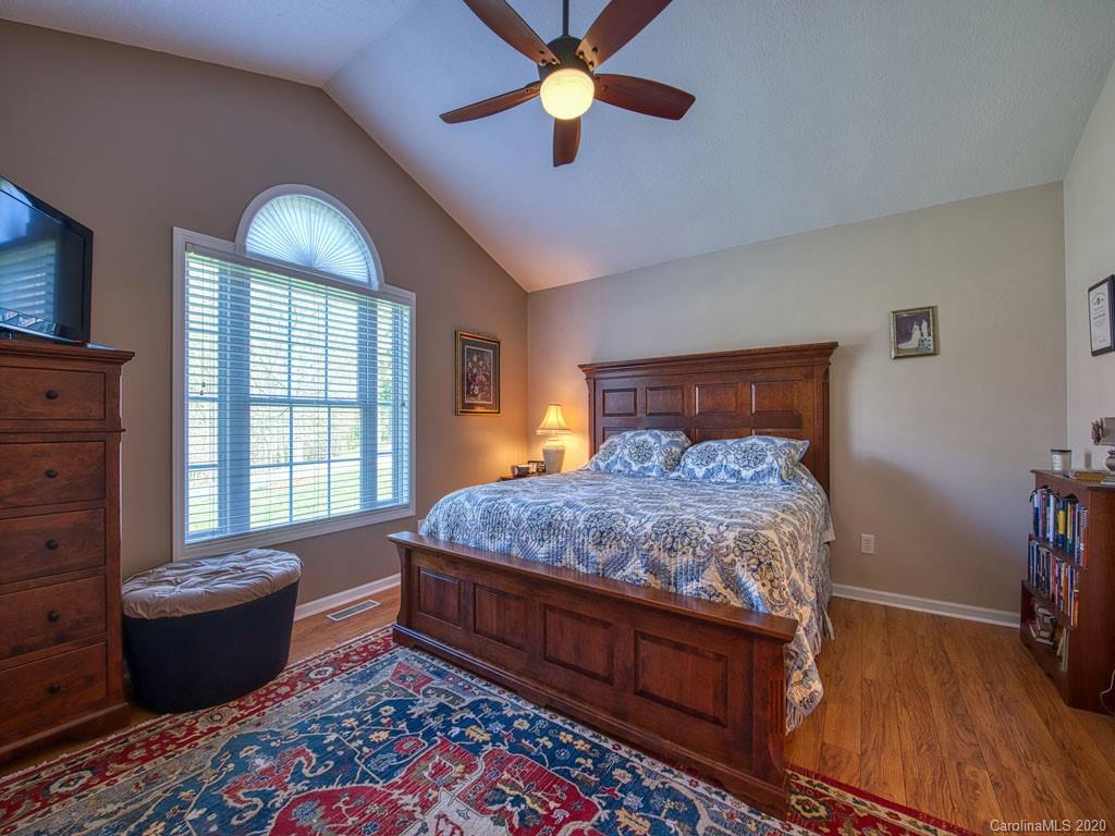 208 Oak Ridge Drive Clyde, NC 28721 - Photo 18 of 36 a bedroom with a bed and a chandelier