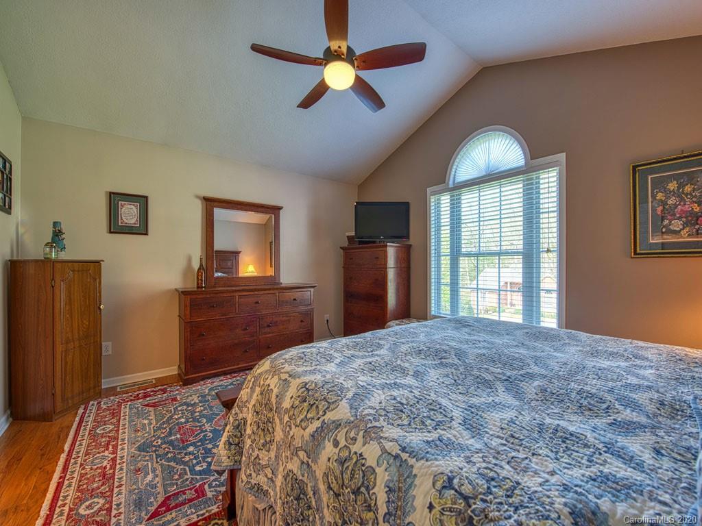208 Oak Ridge Drive Clyde, NC 28721 - Photo 19 of 36 a bedroom with a bed dresser and a window