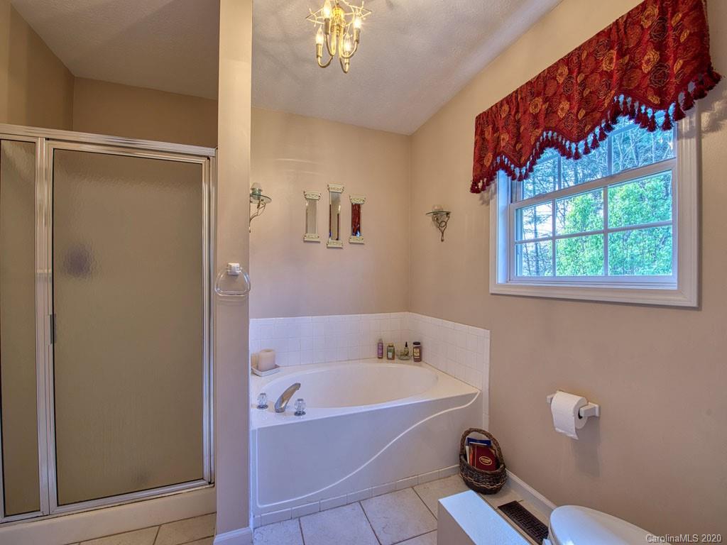 208 Oak Ridge Drive Clyde, NC 28721 - Photo 22 of 36 a bathroom with a tub and a shower