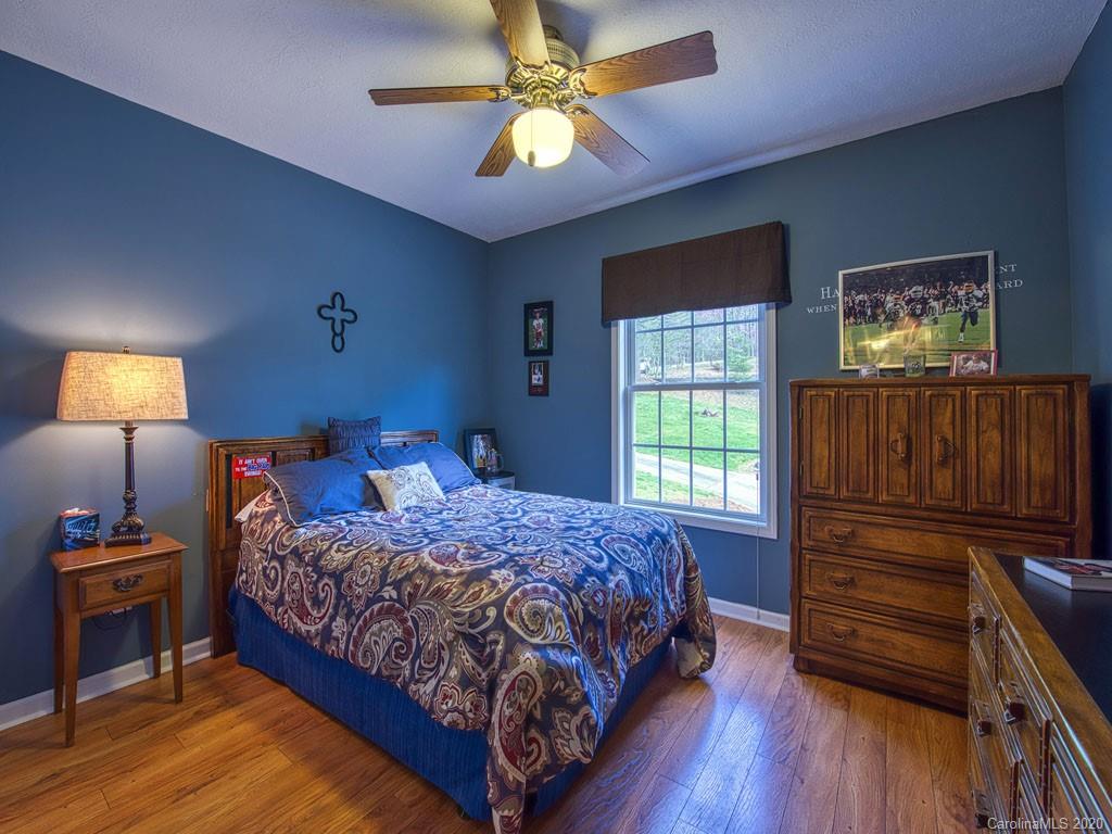 208 Oak Ridge Drive Clyde, NC 28721 - Photo 23 of 36 a bedroom with a bed and wooden floor