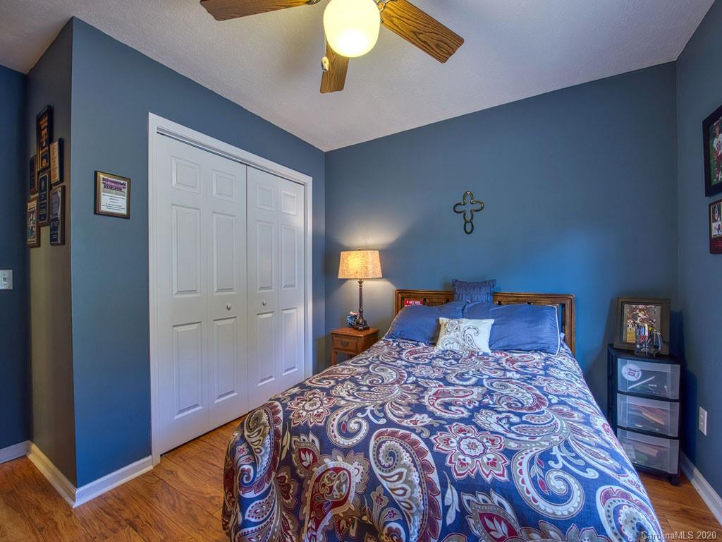 208 Oak Ridge Drive Clyde, NC 28721 - Photo 24 of 36 a bedroom with a large bed and a chandelier
