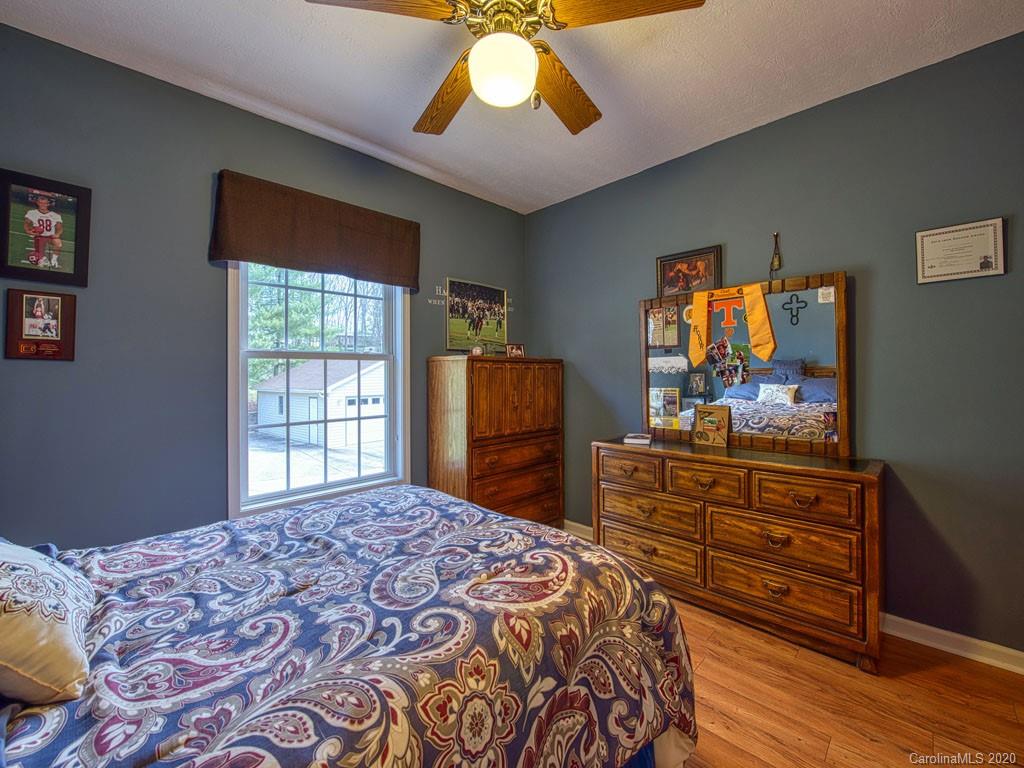 208 Oak Ridge Drive Clyde, NC 28721 - Photo 25 of 36 a bedroom with a bed and a dresser in it