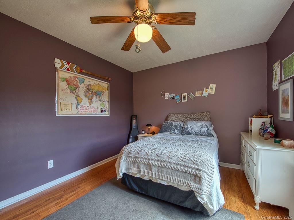 208 Oak Ridge Drive Clyde, NC 28721 - Photo 28 of 36 a bedroom with a bed and a chandelier