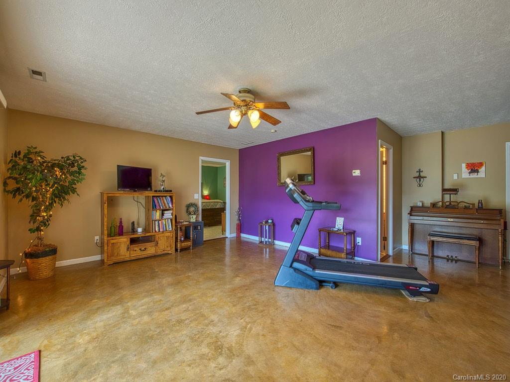 208 Oak Ridge Drive Clyde, NC 28721 - Photo 31 of 36 a living room with furniture gym equipment and a chandelier