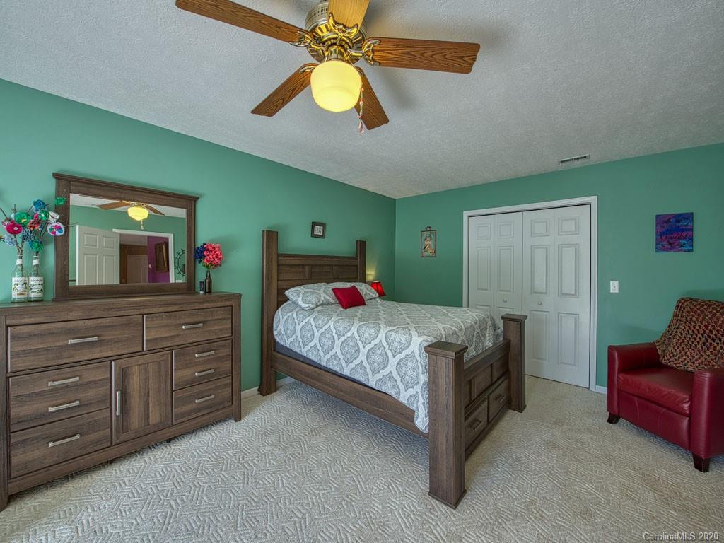 208 Oak Ridge Drive Clyde, NC 28721 - Photo 33 of 36 a bedroom with a bed and a chandelier