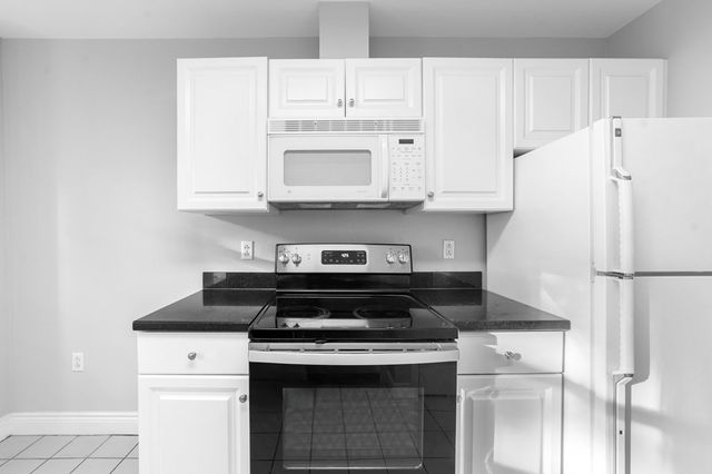a white stove top oven sitting inside of a kitchen