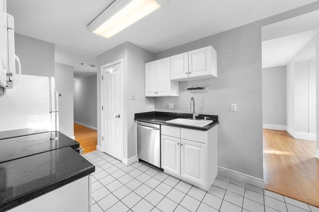 a kitchen with white cabinets and appliances