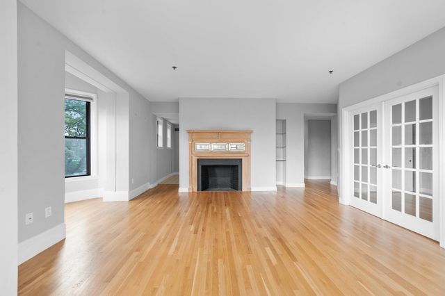 wooden floor fireplace and windows in an empty room