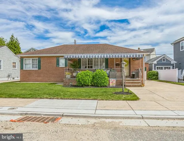 a front view of a house with a garden and plants