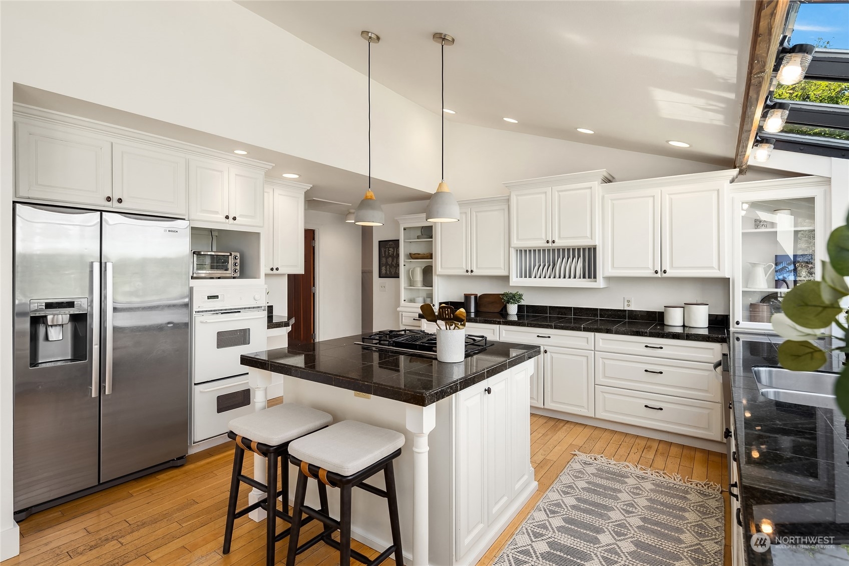 6024 Rose Loop Northeast Bainbridge Island, WA 98110 - Photo 13 of 40 a kitchen with stainless steel appliances a stove a sink a refrigerator a center island and furniture