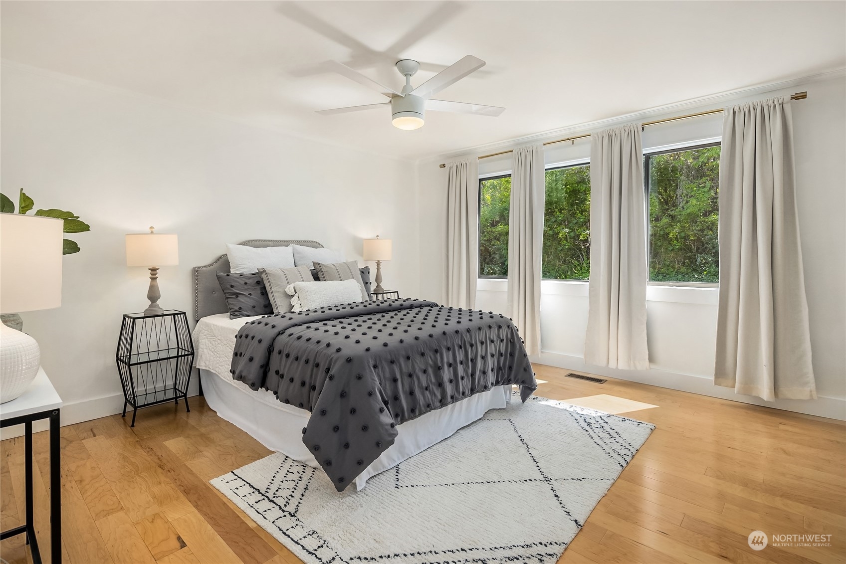 6024 Rose Loop Northeast Bainbridge Island, WA 98110 - Photo 16 of 40 a spacious bedroom with a bed painting on wall and a large window