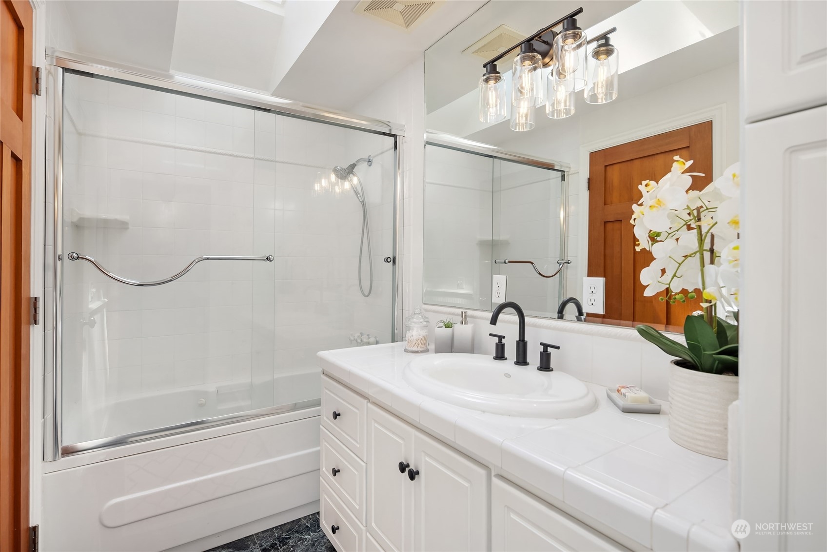 6024 Rose Loop Northeast Bainbridge Island, WA 98110 - Photo 17 of 40 a bathroom with a sink a vanity a mirror and a shower