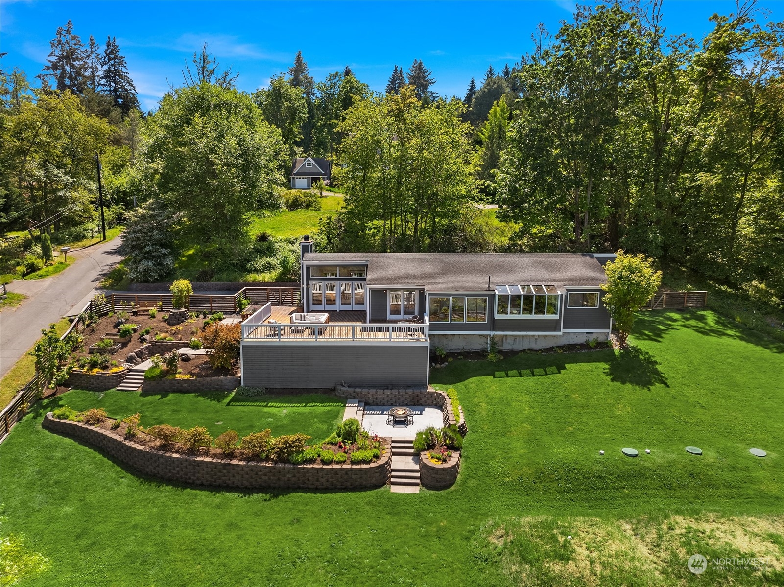 6024 Rose Loop Northeast Bainbridge Island, WA 98110 - Photo 33 of 40 a aerial view of a house with swimming pool lawn chairs and a fire pit