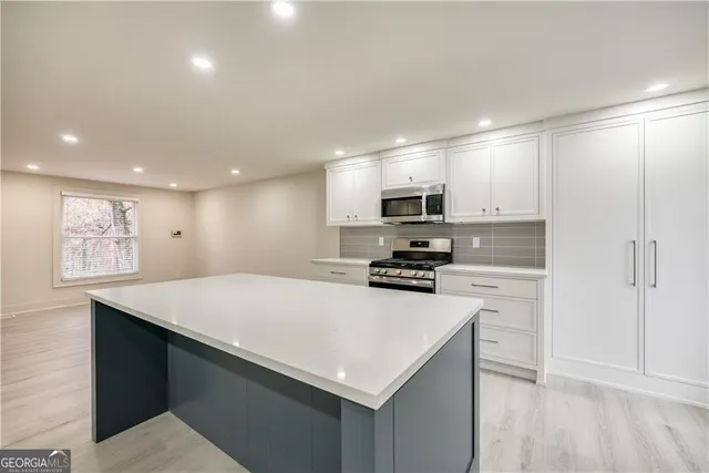 a kitchen with stainless steel appliances a microwave sink refrigerator and cabinets
