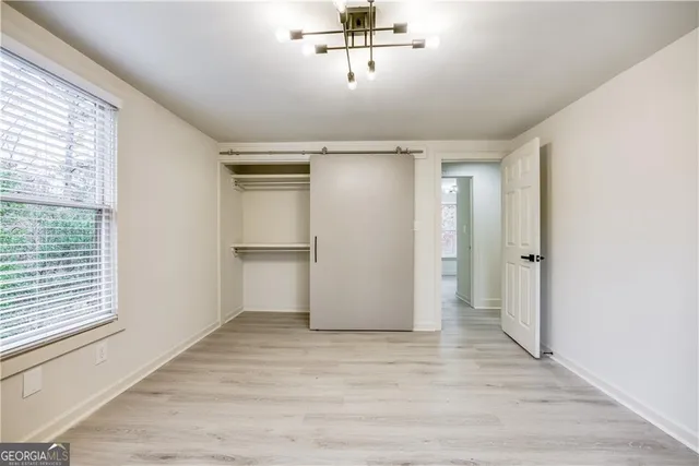 a view of empty room with wooden floor and window