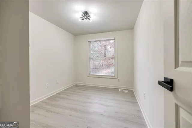an empty room with windows and closet