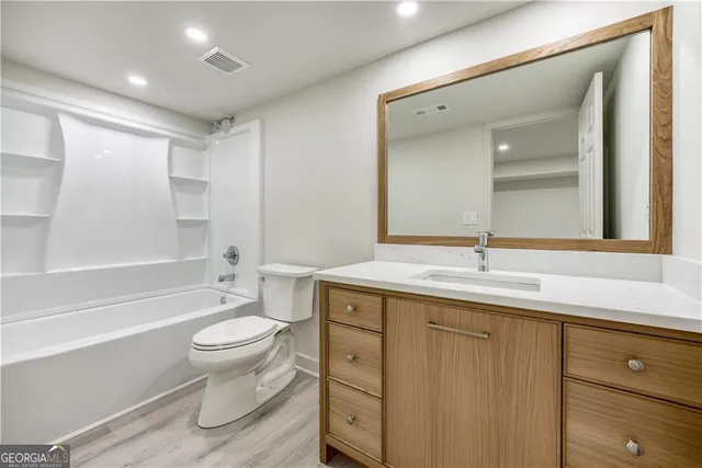 a bathroom with a granite countertop toilet a sink and a bathtub