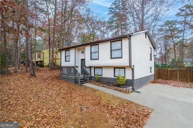 a white house that has a tree in front of it
