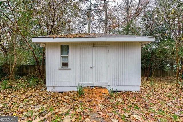 a backyard of a house with barbeque oven table and chairs