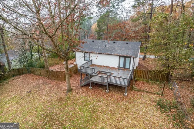 a view of a house with a yard balcony and wooden fence