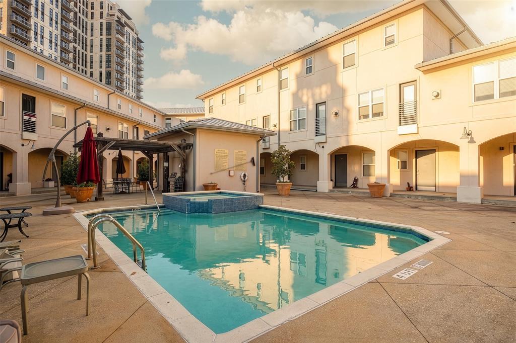 3922 Gilbert Avenue, Unit 214 Dallas, TX 75219 - Photo 25 of 27 Community pool with an integrated spa, surrounded by concrete decking and archway-framed entrances