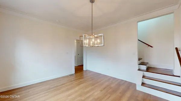 a view of a room with wooden floor and ceiling fan