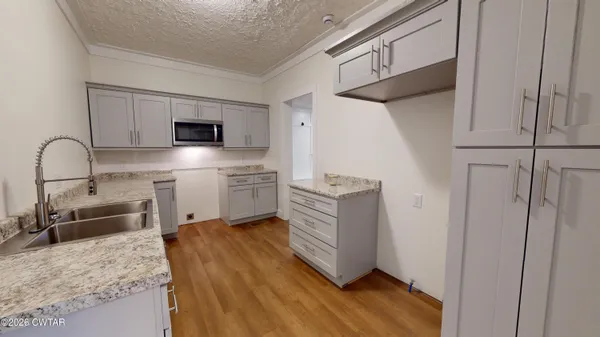 a kitchen with a refrigerator sink and white cabinets