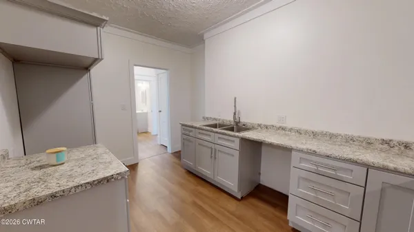 a kitchen with granite countertop a sink and a stove