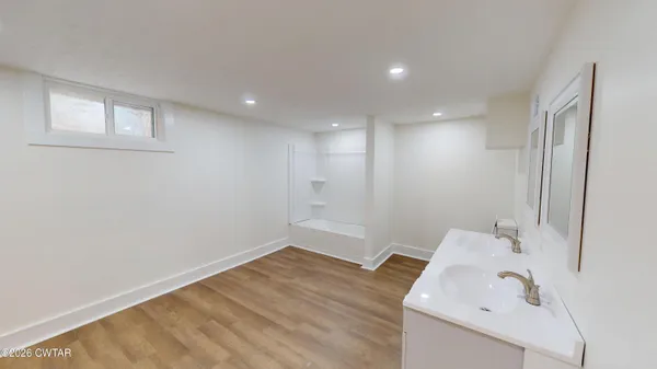 a bathroom with a tub sink and mirror