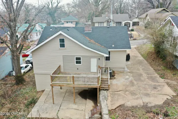 a view of wooden house with a small deck