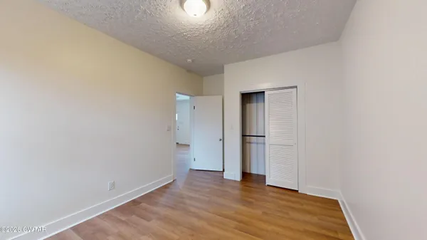 a view of an empty room with wooden floor