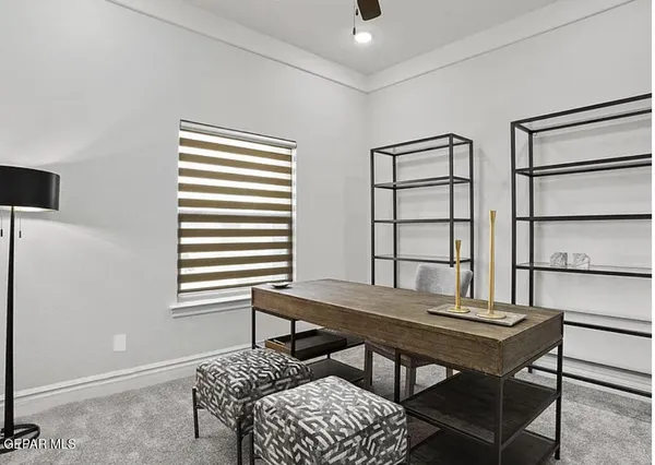 a view of a workspace with furniture and a window