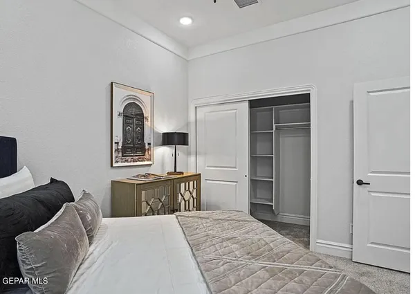 a room with a bed and a view of living room