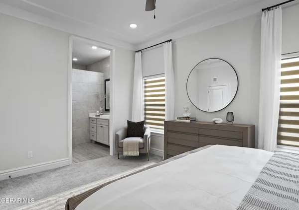 a large bedroom with a bed large mirror and a large window