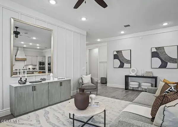 a living room with furniture kitchen view and a wooden floor
