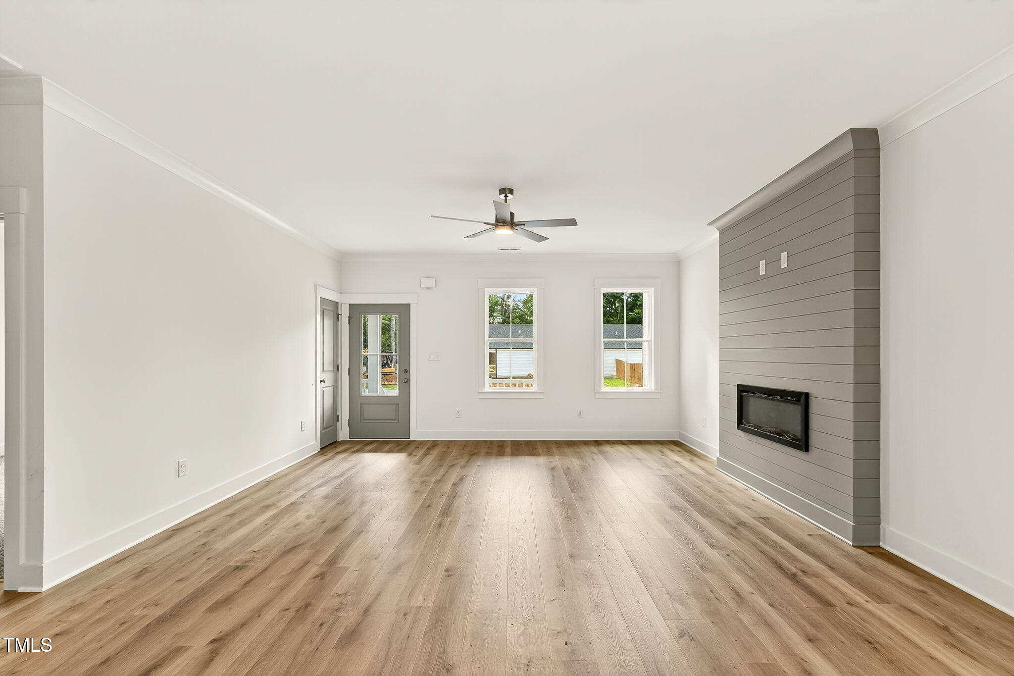 213 Maye Street Dunn, NC 28334 - Photo 13 of 45 an empty room with wooden floor fireplace and windows