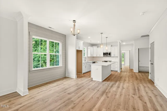 a large kitchen with a lot of counter space and wooden floor